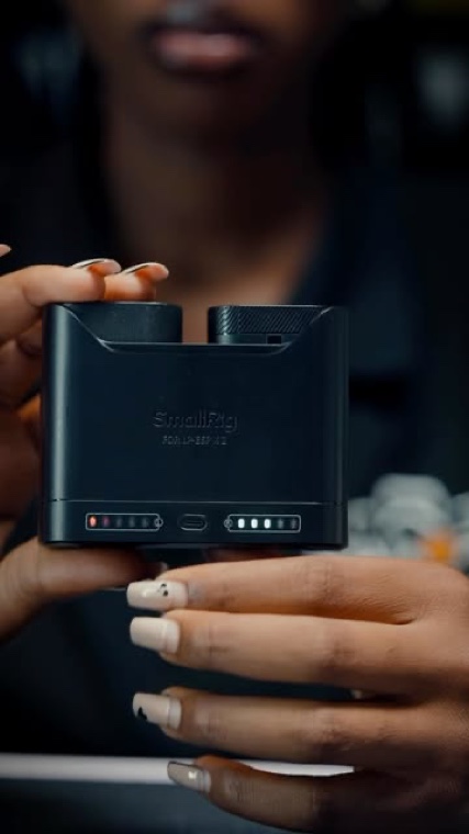 A SmallRig battery charger held to camera